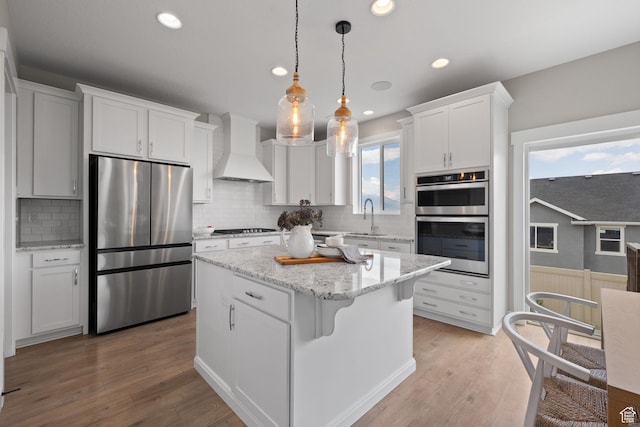 3256 S Iron Hill Cir, Saratoga Springs, UT 84045 - kitchen featuring stainless steel appliances, custom exhaust hood, white cabinetry, a kitchen island, and decorative backsplash