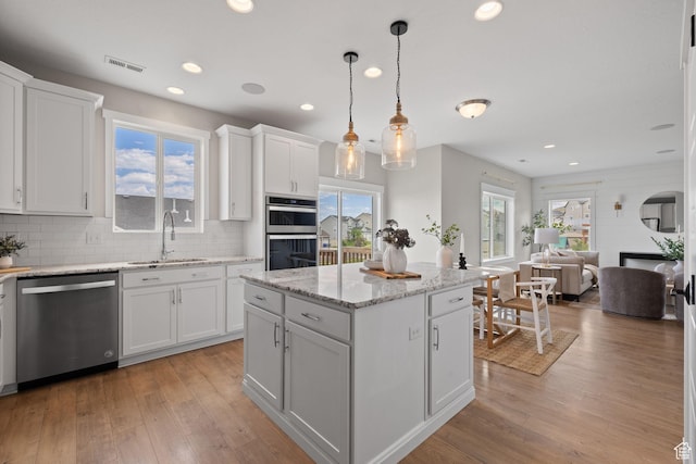 3256 S Iron Hill Cir, Saratoga Springs, UT 84045 - kitchen featuring stainless steel appliances, light wood-type flooring, white cabinetry, decorative backsplash, and recessed lighting