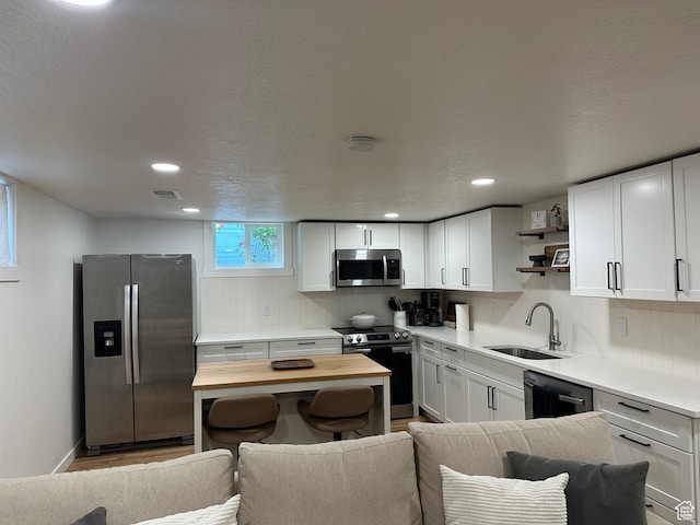 3269 Liberty Ave, Ogden, UT 84403 - kitchen featuring appliances with stainless steel finishes, butcher block countertops, open shelves, backsplash, and white cabinets
