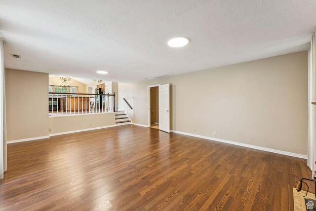 1087 W Barnes Dr, Kaysville, UT 84037 - unfurnished room with a chandelier, wood finished floors, a textured ceiling, and stairs