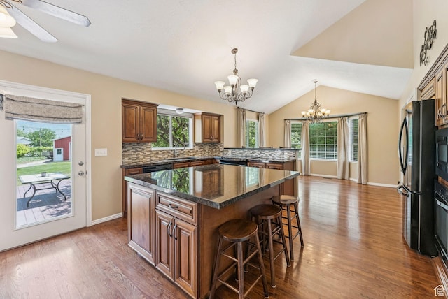 1087 W Barnes Dr, Kaysville, UT 84037 - kitchen with a chandelier, a breakfast bar area, a center island, black appliances, and wood finished floors