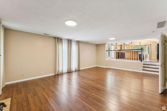 1087 W Barnes Dr, Kaysville, UT 84037 - unfurnished living room featuring a textured ceiling, a chandelier, and wood finished floors
