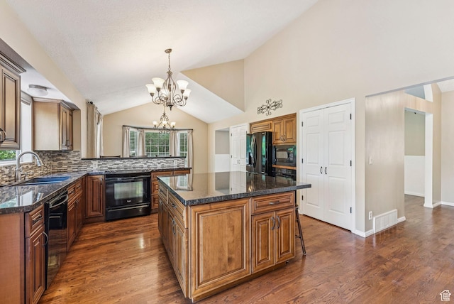 1087 W Barnes Dr, Kaysville, UT 84037 - kitchen with black appliances, a chandelier, vaulted ceiling, backsplash, and dark wood-style floors