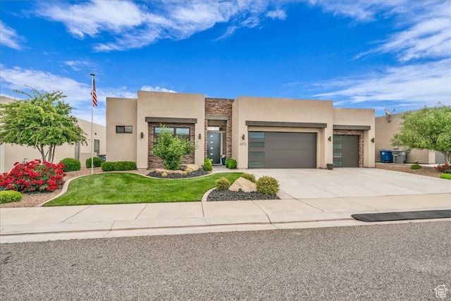 1472 W Pocket Mesa Dr, St George, UT 84770 - pueblo revival-style home with stucco siding, an attached garage, stone siding, driveway, and a front lawn