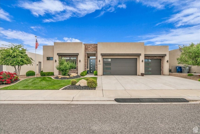 1472 W Pocket Mesa Dr, St George, UT 84770 - pueblo-style house featuring stucco siding, an attached garage, driveway, a front yard, and stone siding