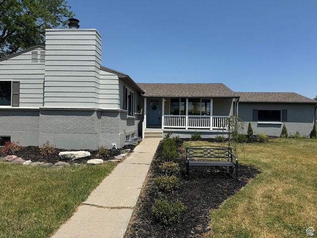 1371 E Skyview Dr, Millcreek, UT 84124 - view of front of home featuring covered porch, brick siding, a front lawn, and a chimney