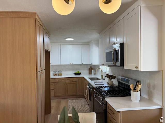 1371 E Skyview Dr, Millcreek, UT 84124 - kitchen featuring appliances with stainless steel finishes, backsplash, light stone countertops, and light wood finished floors