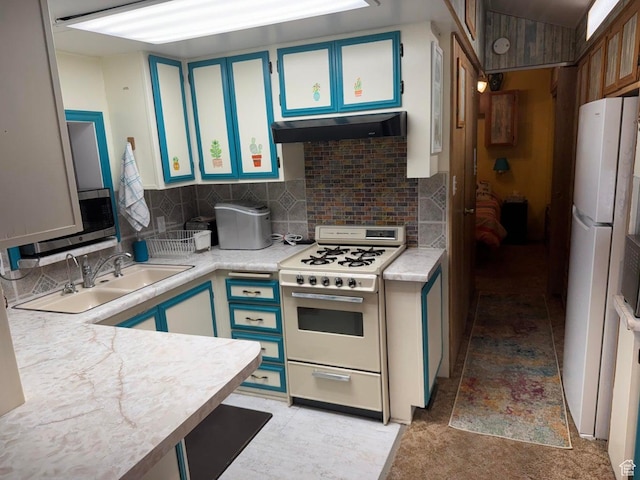 1225 N Dixie Downs Rd Unit 100, St George, UT 84770 - kitchen with white appliances, light countertops, backsplash, under cabinet range hood, and blue cabinetry