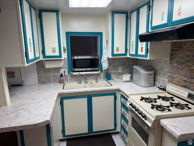 1225 N Dixie Downs Rd Unit 100, St George, UT 84770 - kitchen featuring white gas range, stainless steel microwave, light countertops, backsplash, and blue cabinetry