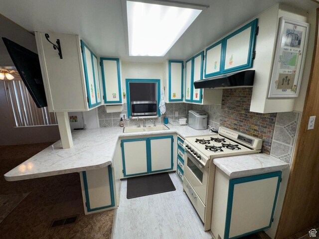 1225 N Dixie Downs Rd Unit 100, St George, UT 84770 - kitchen featuring white range with gas cooktop, under cabinet range hood, light countertops, and stainless steel microwave
