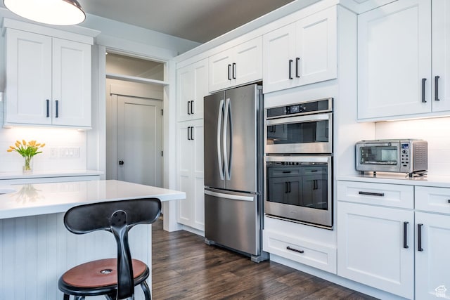 2452 E Lone Hill Dr Unit 324, Draper Ut Cnty, UT 84020 - kitchen featuring appliances with stainless steel finishes, dark wood-style floors, a kitchen breakfast bar, and white cabinetry