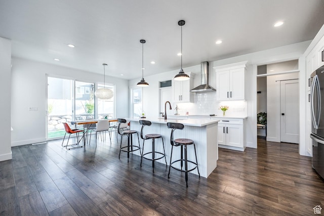 2452 E Lone Hill Dr Unit 324, Draper Ut Cnty, UT 84020 - kitchen featuring wall chimney exhaust hood, a kitchen bar, recessed lighting, white cabinets, and a kitchen island with sink