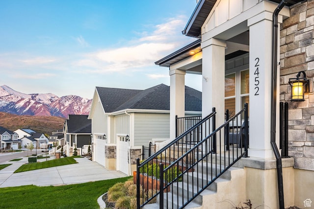 2452 E Lone Hill Dr Unit 324, Draper Ut Cnty, UT 84020 - view of property exterior with board and batten siding, a mountain view, stone siding, a shingled roof, and a residential view