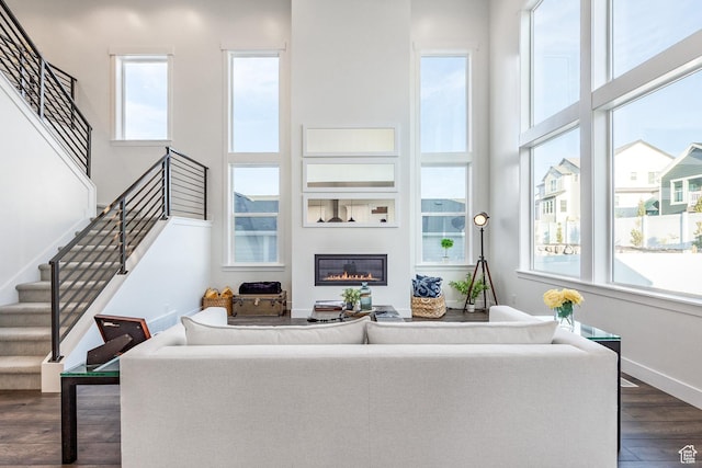 2452 E Lone Hill Dr Unit 324, Draper Ut Cnty, UT 84020 - living area featuring dark wood-style flooring, a glass covered fireplace, stairs, and a high ceiling