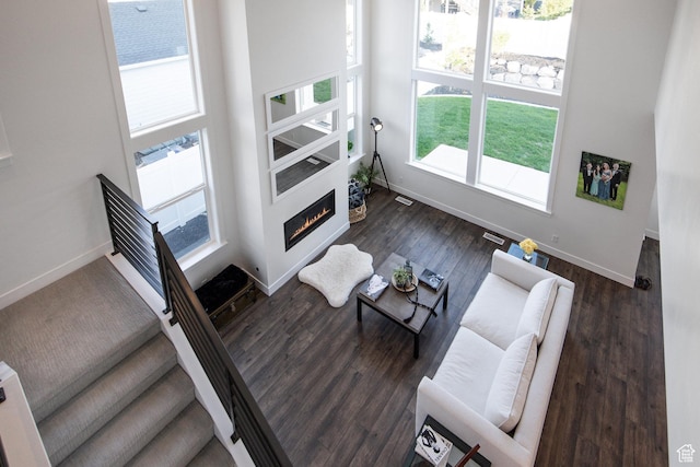 2452 E Lone Hill Dr Unit 324, Draper Ut Cnty, UT 84020 - living room featuring plenty of natural light, a glass covered fireplace, dark wood-type flooring, and a towering ceiling