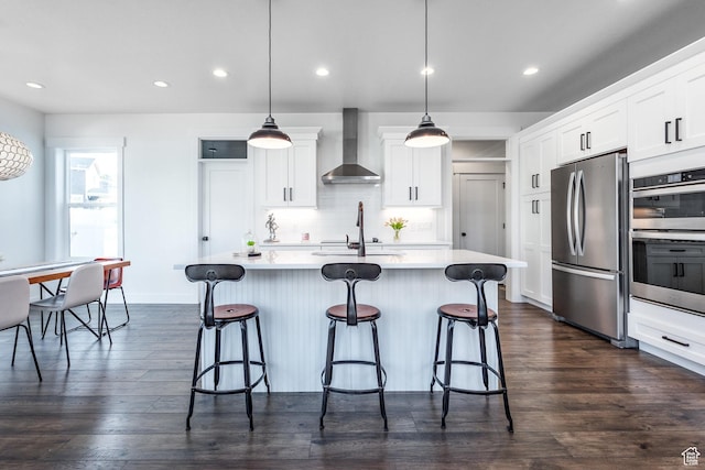 2452 E Lone Hill Dr Unit 324, Draper Ut Cnty, UT 84020 - kitchen with wall chimney range hood, stainless steel appliances, a kitchen breakfast bar, light countertops, and tasteful backsplash