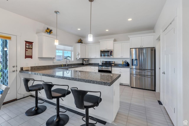 766 S Aspen Cir, Provo, UT 84606 - kitchen with appliances with stainless steel finishes, a peninsula, white cabinetry, a breakfast bar, and recessed lighting