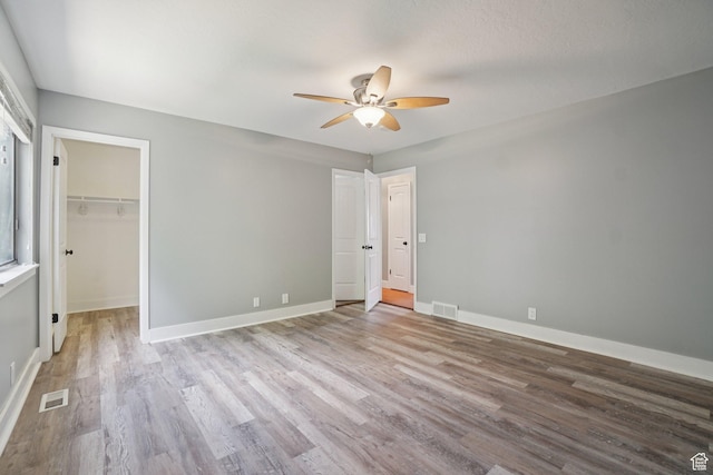 8892 S Flatiron Dr, Sandy, UT 84093 - unfurnished bedroom featuring wood finished floors, ceiling fan, and a spacious closet