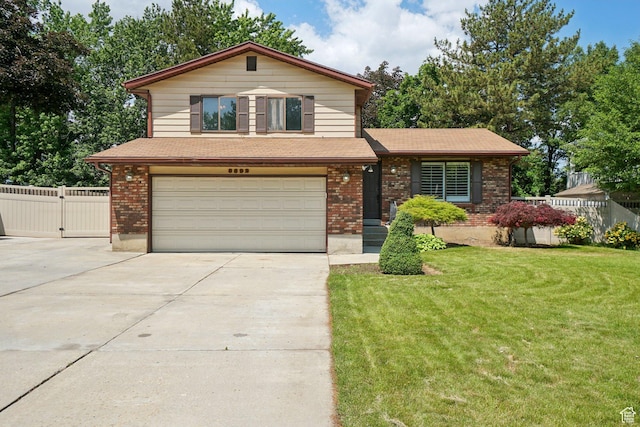 8892 S Flatiron Dr, Sandy, UT 84093 - view of front of home with an attached garage, concrete driveway, brick siding, and a gate