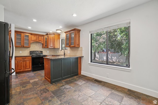 8892 S Flatiron Dr, Sandy, UT 84093 - kitchen featuring black appliances, brown cabinets, a peninsula, decorative backsplash, and stone tile floors