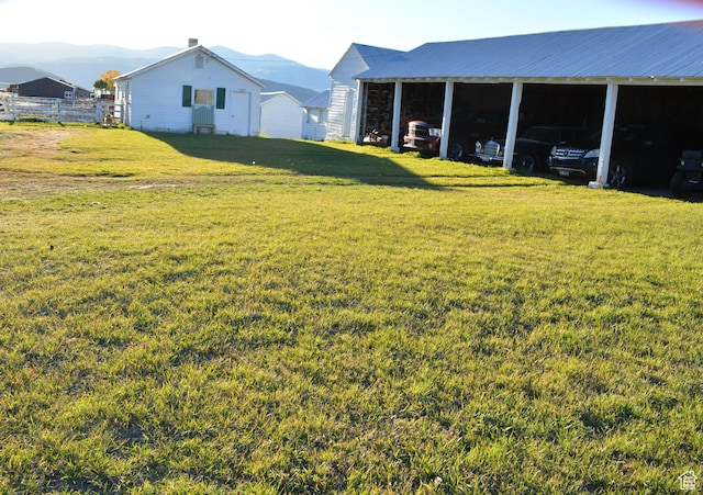 114 W 7th St, Georgetown, ID 83239 - view of grassy yard featuring a carport, a mountain view, and an outbuilding