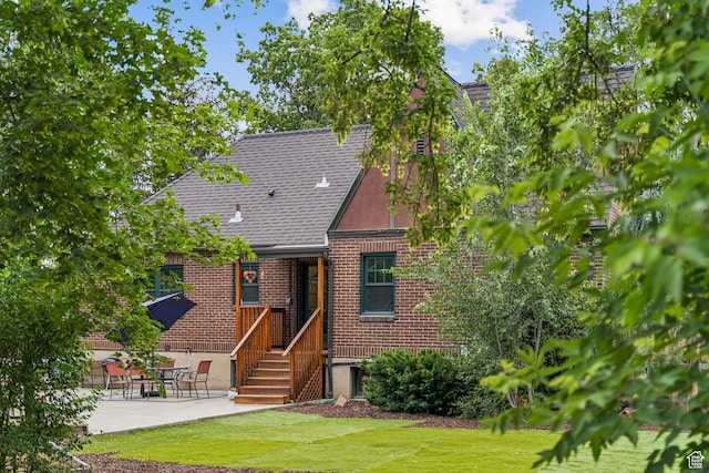 1710 E 900 S, Salt Lake City, UT 84108 - english style home with brick siding, a front lawn, a patio, and a shingled roof