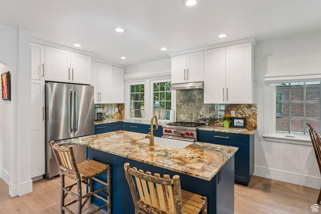 1710 E 900 S, Salt Lake City, UT 84108 - kitchen featuring appliances with stainless steel finishes, under cabinet range hood, light wood-style flooring, a breakfast bar area, and recessed lighting