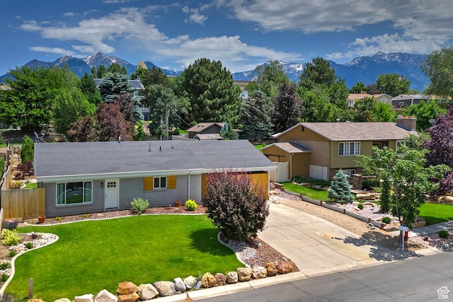 7669 S 1130 E, Midvale, UT 84047 - view of front of property with a mountain view, driveway, brick siding, and roof with shingles