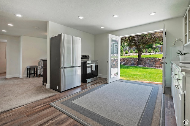 7669 S 1130 E, Midvale, UT 84047 - kitchen with appliances with stainless steel finishes, wood finished floors, recessed lighting, white cabinets, and a textured ceiling