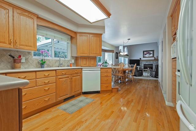 1222 E Big Pine Cir, Sandy, UT 84094 - kitchen with white appliances, light wood-style floors, decorative backsplash, light countertops, and a warm lit fireplace