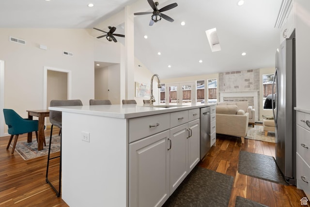 3569 E Avondale Dr S, Cottonwood Heights, UT 84121 - kitchen with open floor plan, stainless steel appliances, white cabinetry, dark wood finished floors, and a skylight