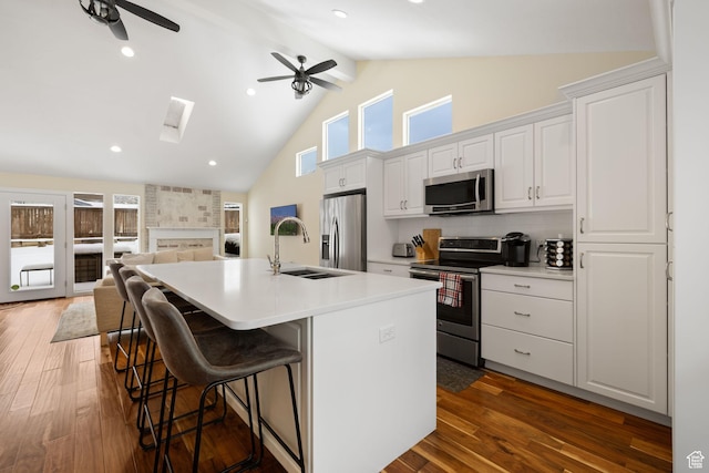 3569 E Avondale Dr S, Cottonwood Heights, UT 84121 - kitchen with stainless steel appliances, a ceiling fan, a kitchen island with sink, high vaulted ceiling, and a kitchen breakfast bar