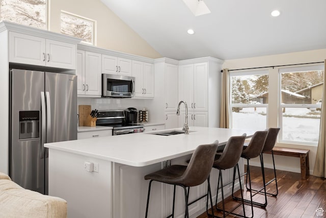 3569 E Avondale Dr S, Cottonwood Heights, UT 84121 - kitchen with appliances with stainless steel finishes, white cabinetry, decorative backsplash, vaulted ceiling, and a skylight