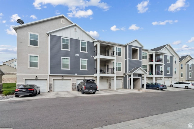 14654 S Bloom Dr W Unit K301, Herriman, UT 84096 - view of front facade featuring board and batten siding, an attached garage, a residential view, and stone siding