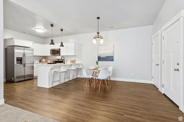 14654 S Bloom Dr W Unit K301, Herriman, UT 84096 - kitchen with appliances with stainless steel finishes, a peninsula, a breakfast bar, light countertops, and a chandelier