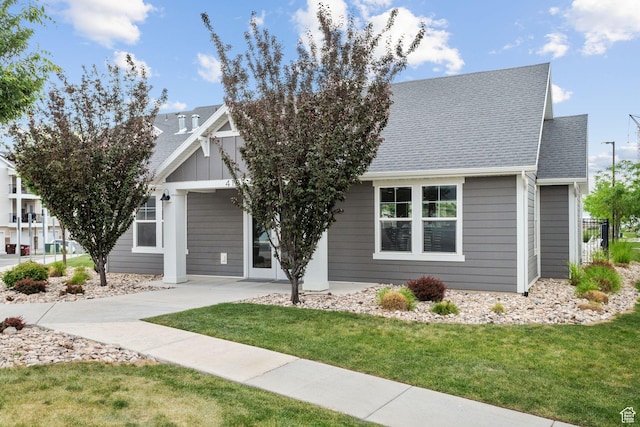 14654 S Bloom Dr W Unit K301, Herriman, UT 84096 - view of front of home featuring a front yard, roof with shingles, and driveway