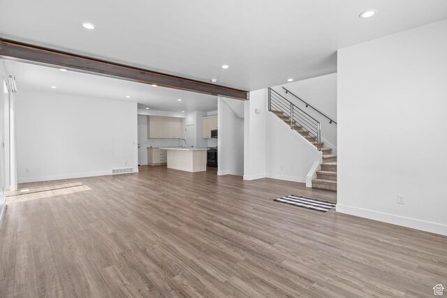 1046 W Albion Meadow Way, Bluffdale, UT 84065 - unfurnished living room with recessed lighting, stairway, and light wood finished floors