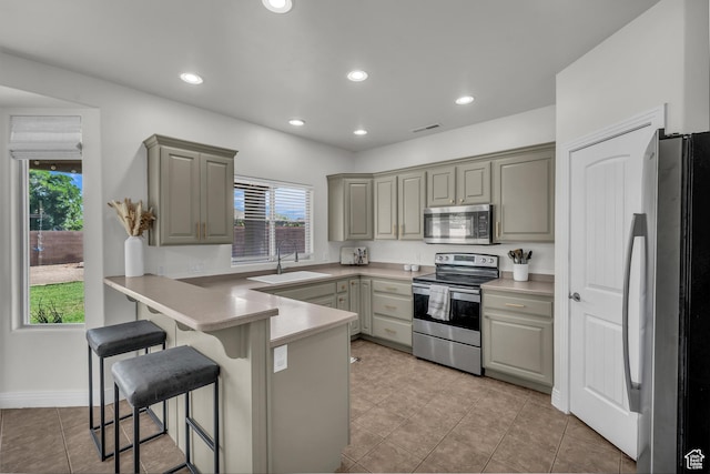 86 W 1965 S, Washington, UT 84780 - kitchen featuring appliances with stainless steel finishes, a peninsula, gray cabinetry, a kitchen bar, and light tile patterned flooring