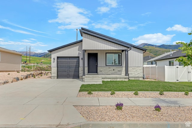 766 N 540 E, Smithfield, UT 84335 - view of front of property with a mountain view, concrete driveway, a garage, and stone siding
