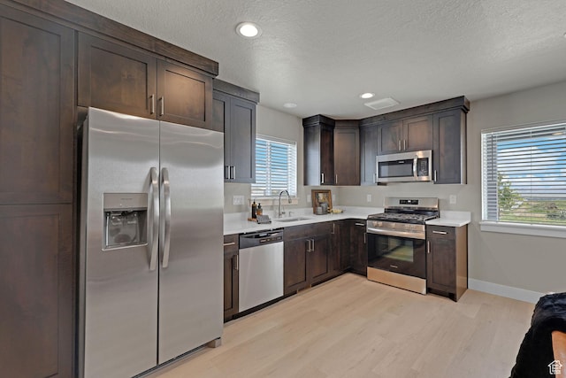 766 N 540 E, Smithfield, UT 84335 - kitchen with stainless steel appliances, light wood-style flooring, light countertops, dark brown cabinetry, and a textured ceiling