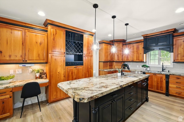 1655 W 2200 S, College Ward, UT 84339 - kitchen with tasteful backsplash, brown cabinetry, light wood-style flooring, light stone counters, and recessed lighting
