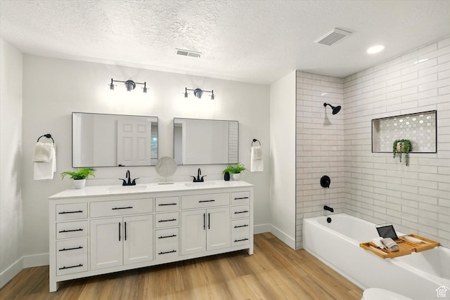 1655 W 2200 S, College Ward, UT 84339 - full bathroom with wood finished floors, double vanity, shower / washtub combination, and a textured ceiling