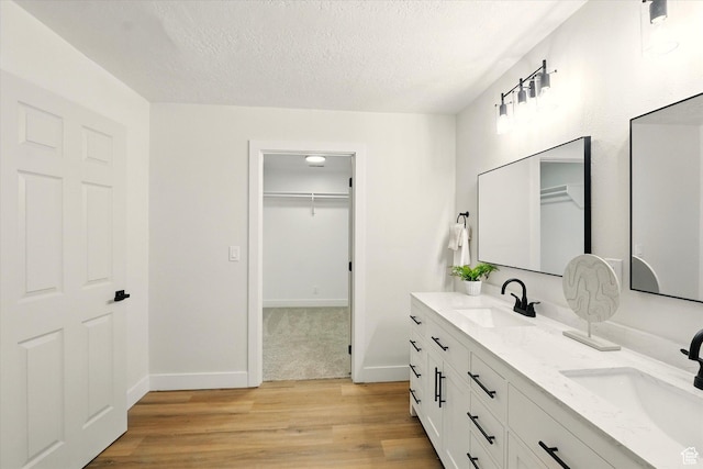 1655 W 2200 S, College Ward, UT 84339 - full bathroom with double vanity, wood finished floors, a textured ceiling, and a walk in closet