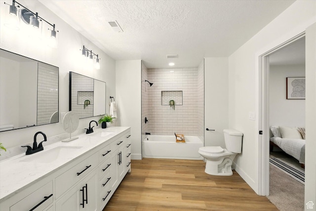1655 W 2200 S, College Ward, UT 84339 - bathroom with wood finished floors, double vanity, a textured ceiling, bathtub / shower combination, and ensuite bath