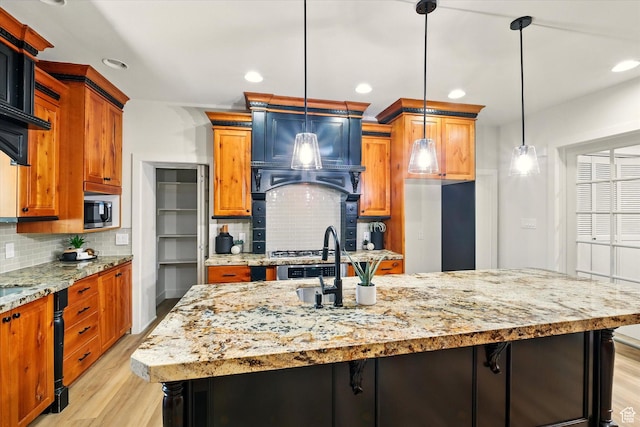 1655 W 2200 S, College Ward, UT 84339 - kitchen with light wood-style floors, decorative backsplash, an island with sink, and recessed lighting
