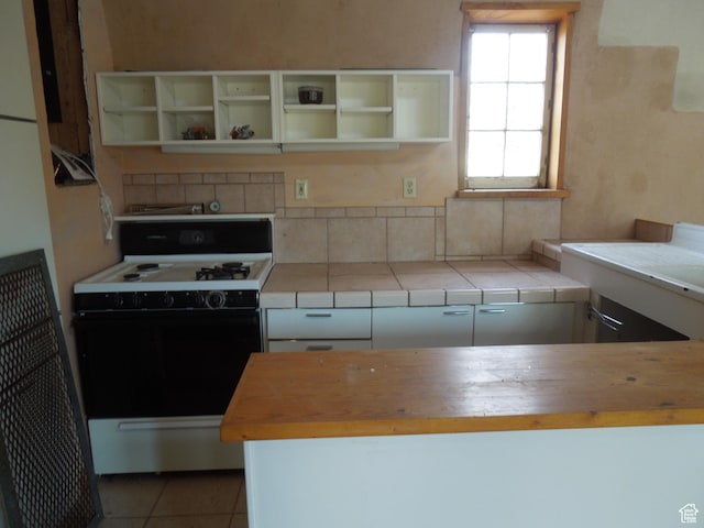313 W Holyoak Ln, Castle Valley, UT 84532 - kitchen with white range oven, butcher block counters, open shelves, light tile patterned floors, and white cabinetry
