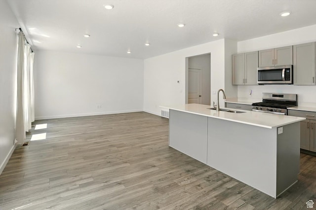 1147 E Fathom Ln, Saratoga Springs, UT 84045 - kitchen featuring stainless steel appliances, gray cabinets, light wood finished floors, an island with sink, and recessed lighting
