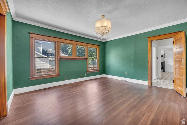 2546 S Fowler, Ogden, UT 84401 - spare room featuring a textured ceiling, a chandelier, wood finished floors, ornamental molding, and a textured wall