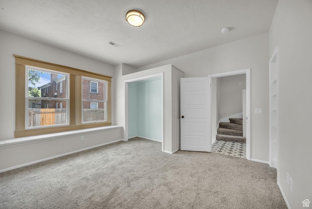 2546 S Fowler, Ogden, UT 84401 - carpeted empty room with a textured ceiling, stairway, and a smoke detector