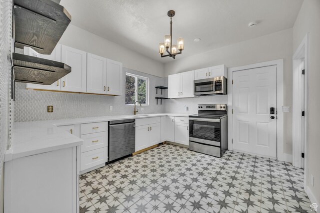 2546 S Fowler, Ogden, UT 84401 - kitchen with stainless steel appliances, light floors, a chandelier, light countertops, and white cabinets
